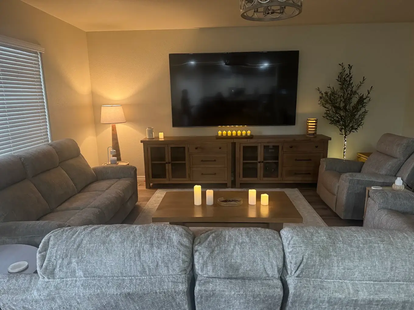 Large flat screen TV wall mounted in living room above media console